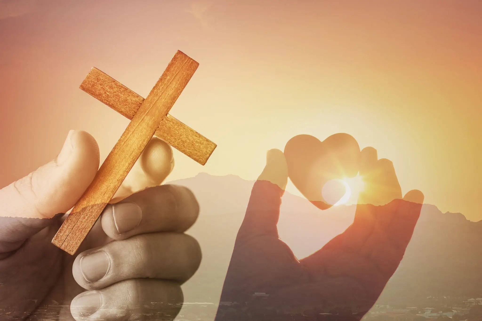 Hand holding cinnamon sticks with heart-shaped shadow at sunset.