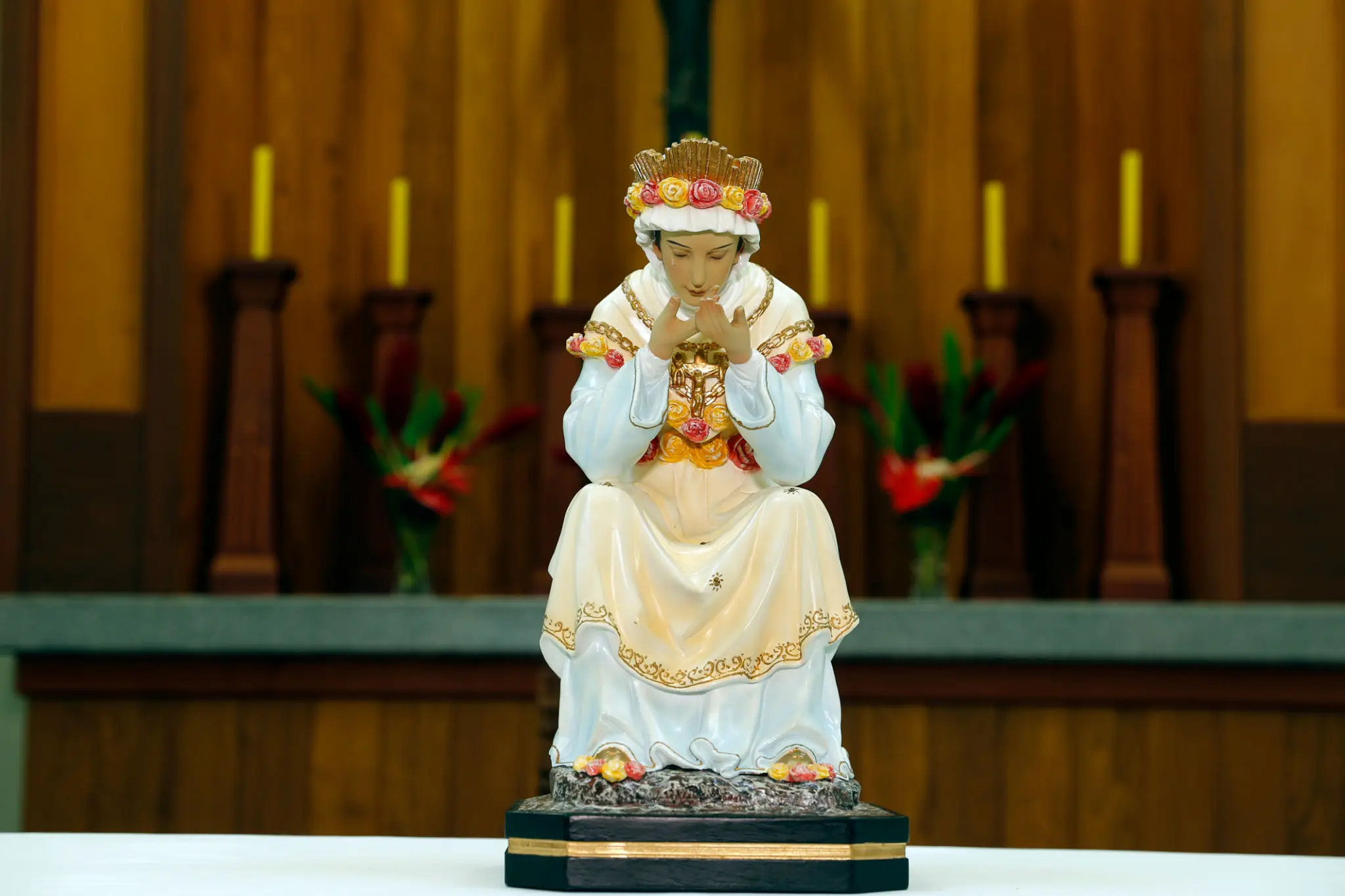 A detailed statue of a saint dressed in white and gold robes.
