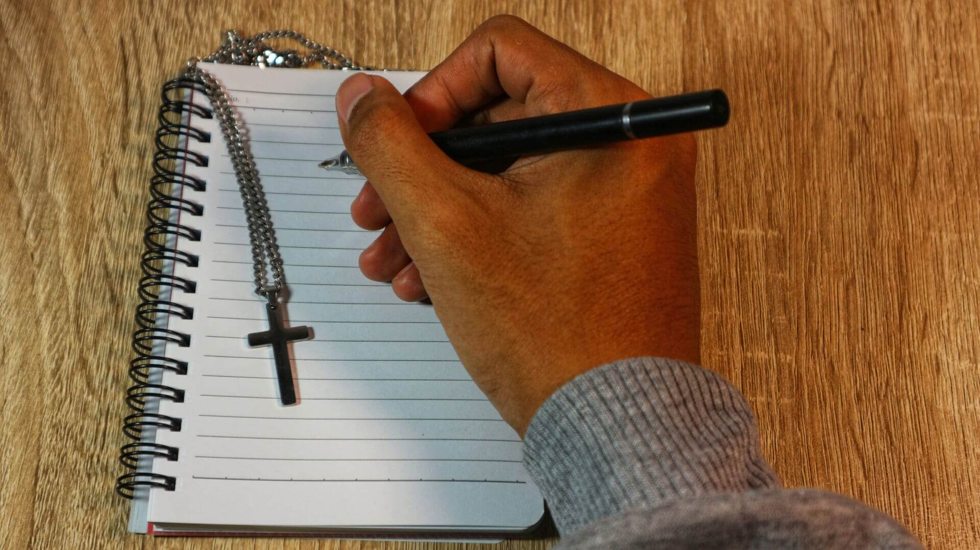 Writing in spiral notebook with pen