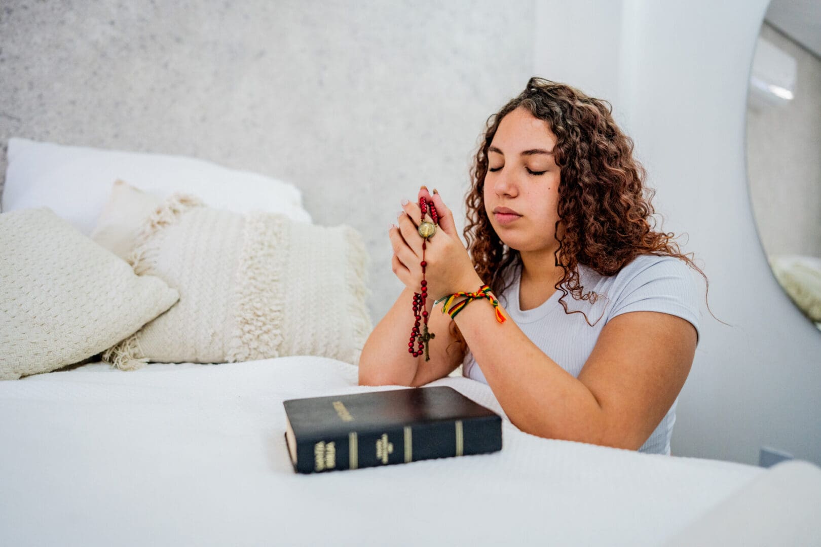 Woman praying with rosary beads