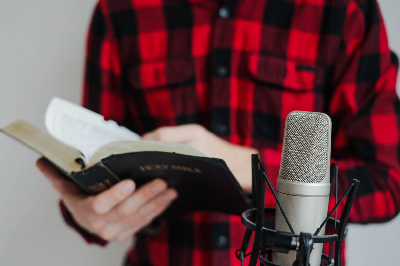 Person reading book near microphone