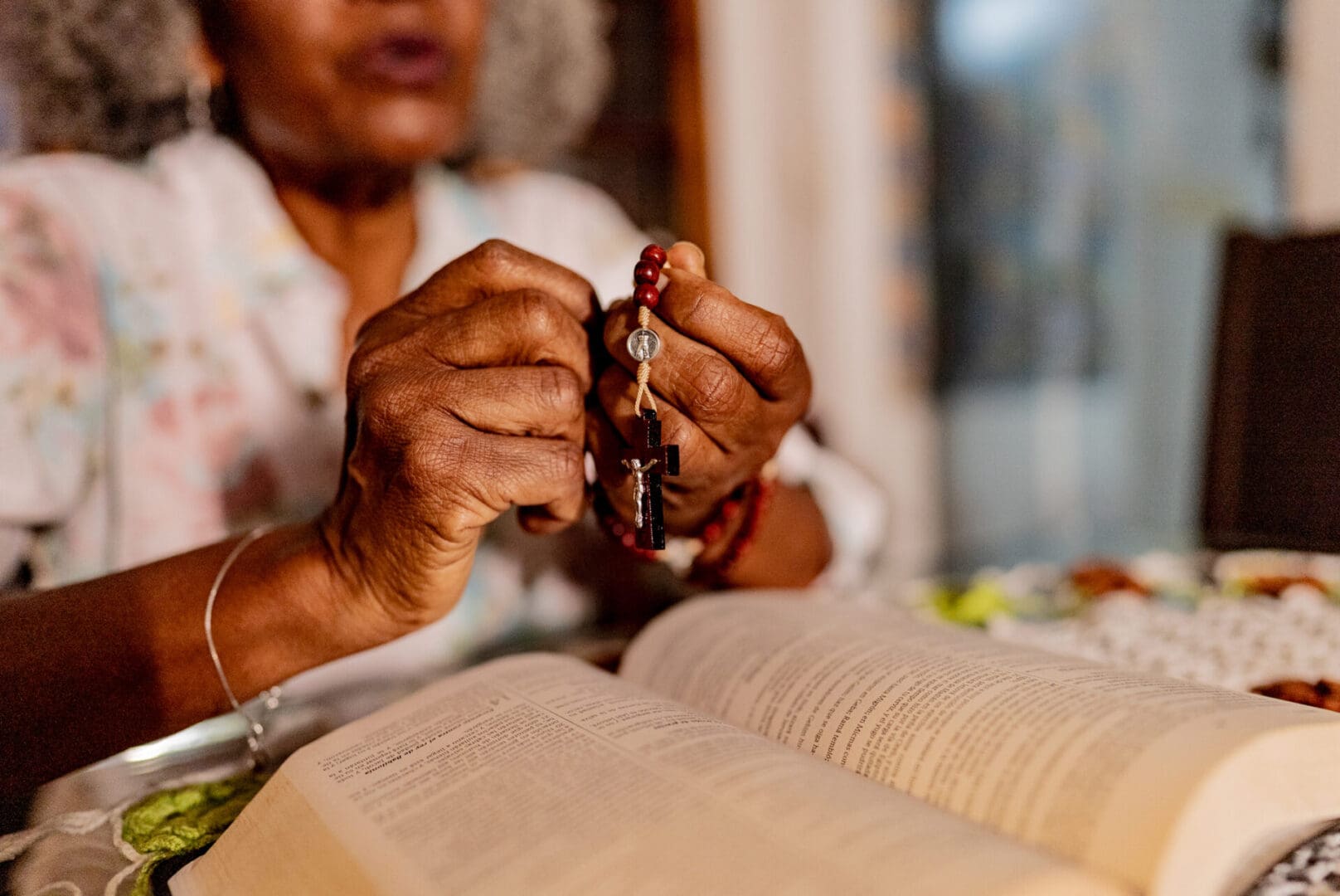 Elderly woman praying with rosary