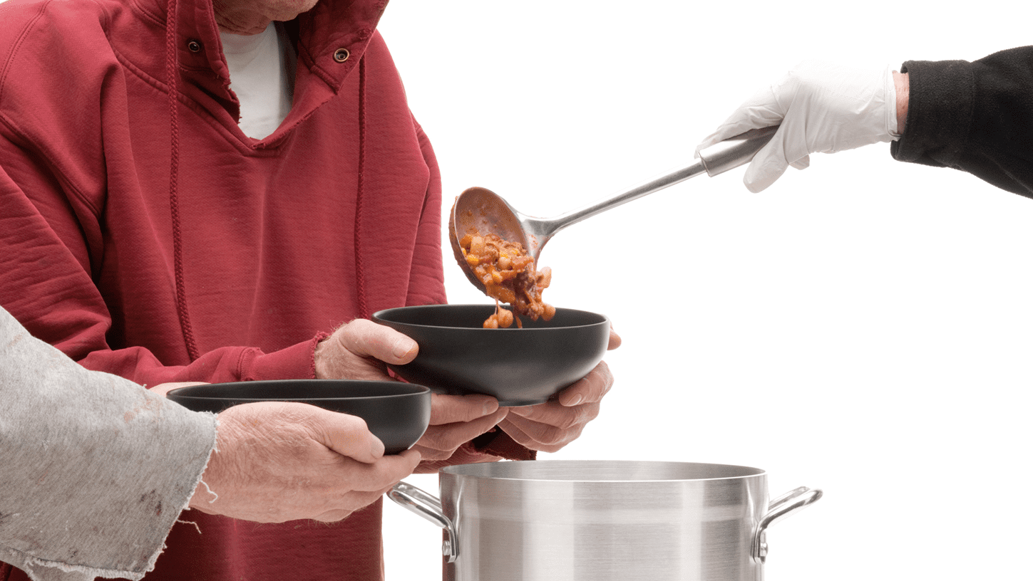 Ladling soup into black bowls for distribution